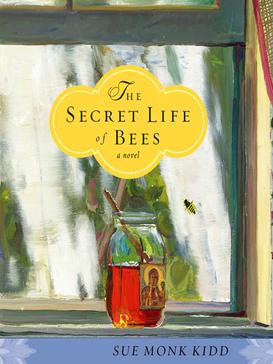 Book cover. The background is an oil painting of an open glass jar of honey sitting on a bright windowsill, a single bee trying to get at it from the other side of the window. The label on the jar appears to be a holy figure, haloed with golden light and one hand uplifted. In a yellow decorative bubble above the jar is the title: "The Secret Life of Bees: a novel." In a light blue bar across the bottom in black text is the author's name: Sue Monk Kidd.